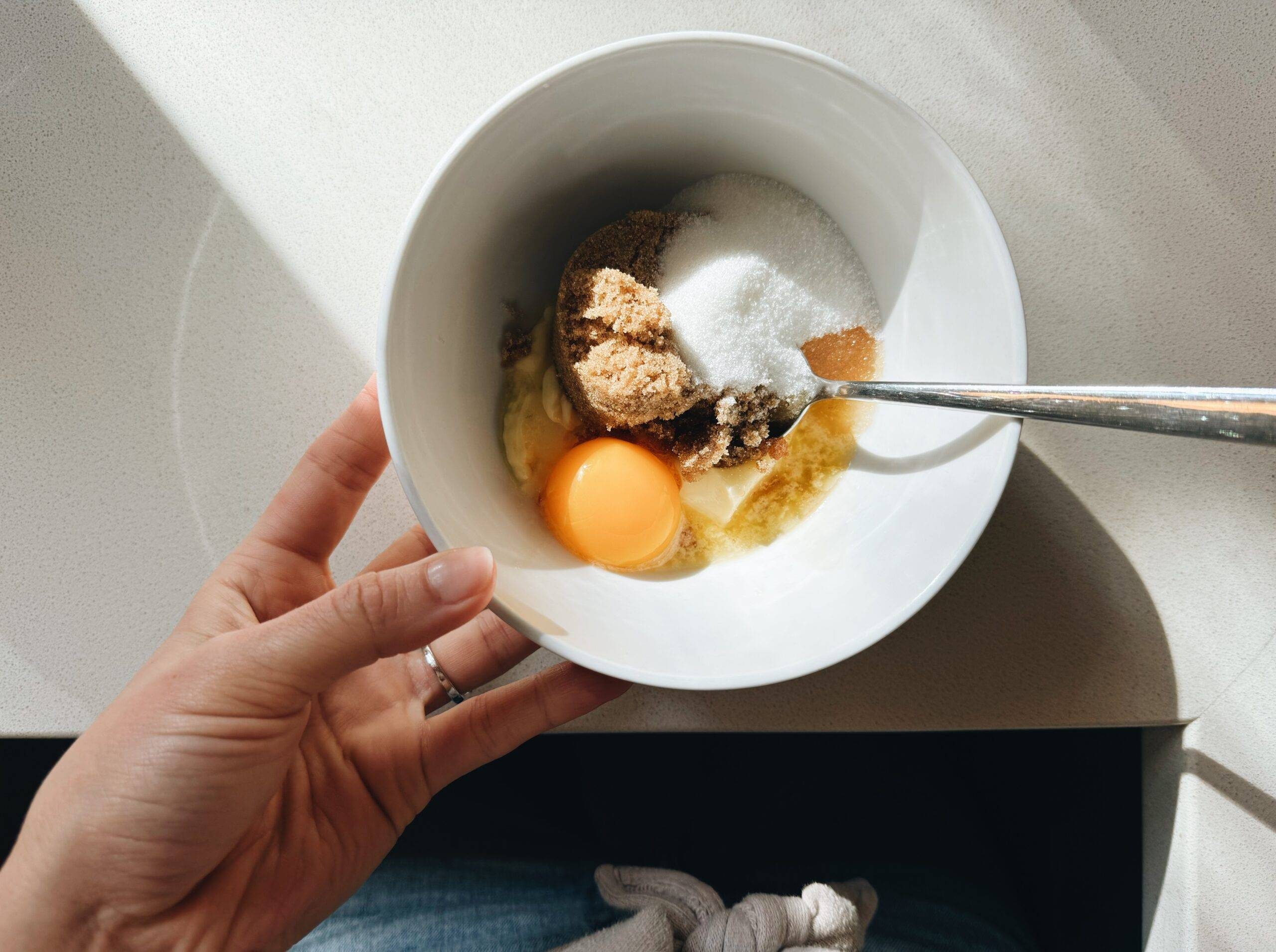 Mixing eggs, butter, and sugar in a bowl.