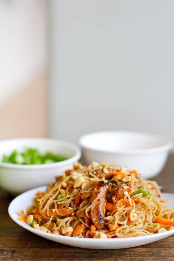 Hoisin pork with rice noodles on a white plate.
