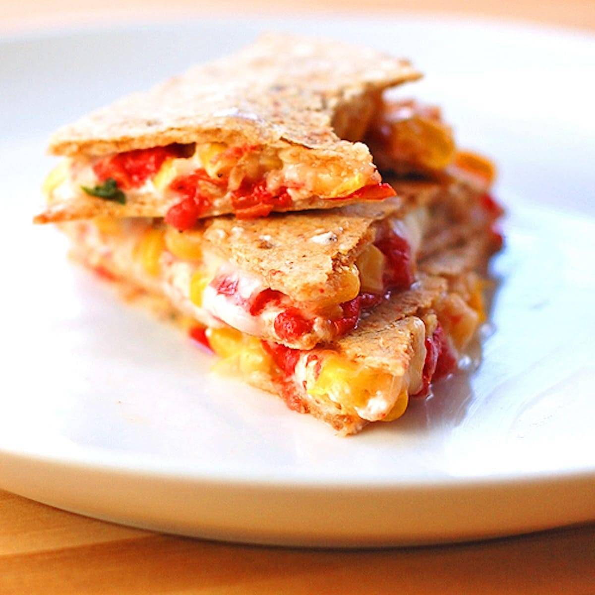 Mozzarella, Basil, and Corn Quesadilla on a white plate.